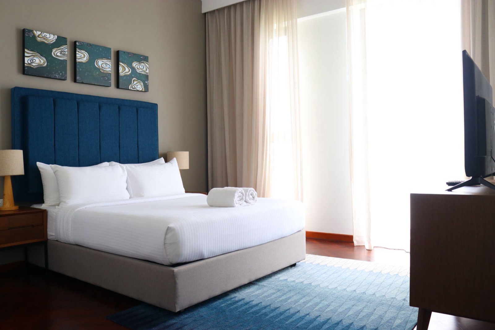 A private room with one double bed beside a bright window at Tanjung Point Residences in Penang